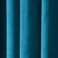 Close-up photograph of lush teal velvet fabric in deep vertical folds catching varied light