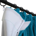 Close-up of a black curtain rod and rings holding a teal velvet curtain with a white pleated liner and light blue stitching