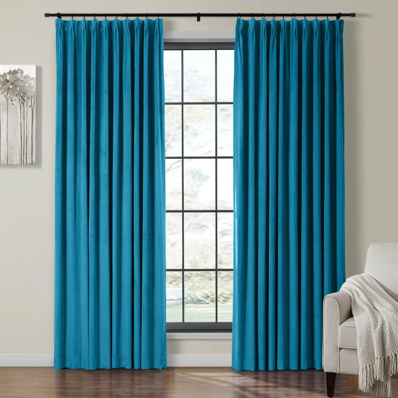 Teal velvet rod pocket curtains in a modern interior, featuring a window view of trees, an abstract grey tree artwork, and a cream armchair with a knitted throw