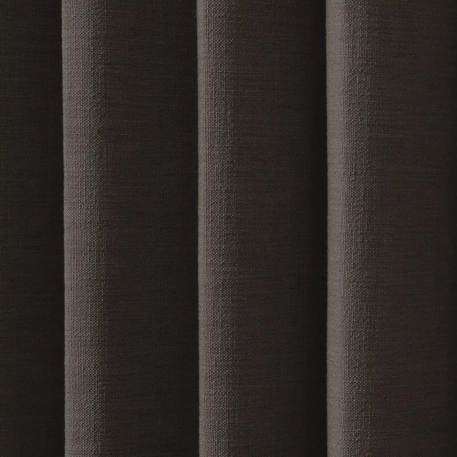 Photograph of dark brown textured fabric showing distinct vertical pleats a coarse woven pattern and subtle highlights on its nubbly surface
