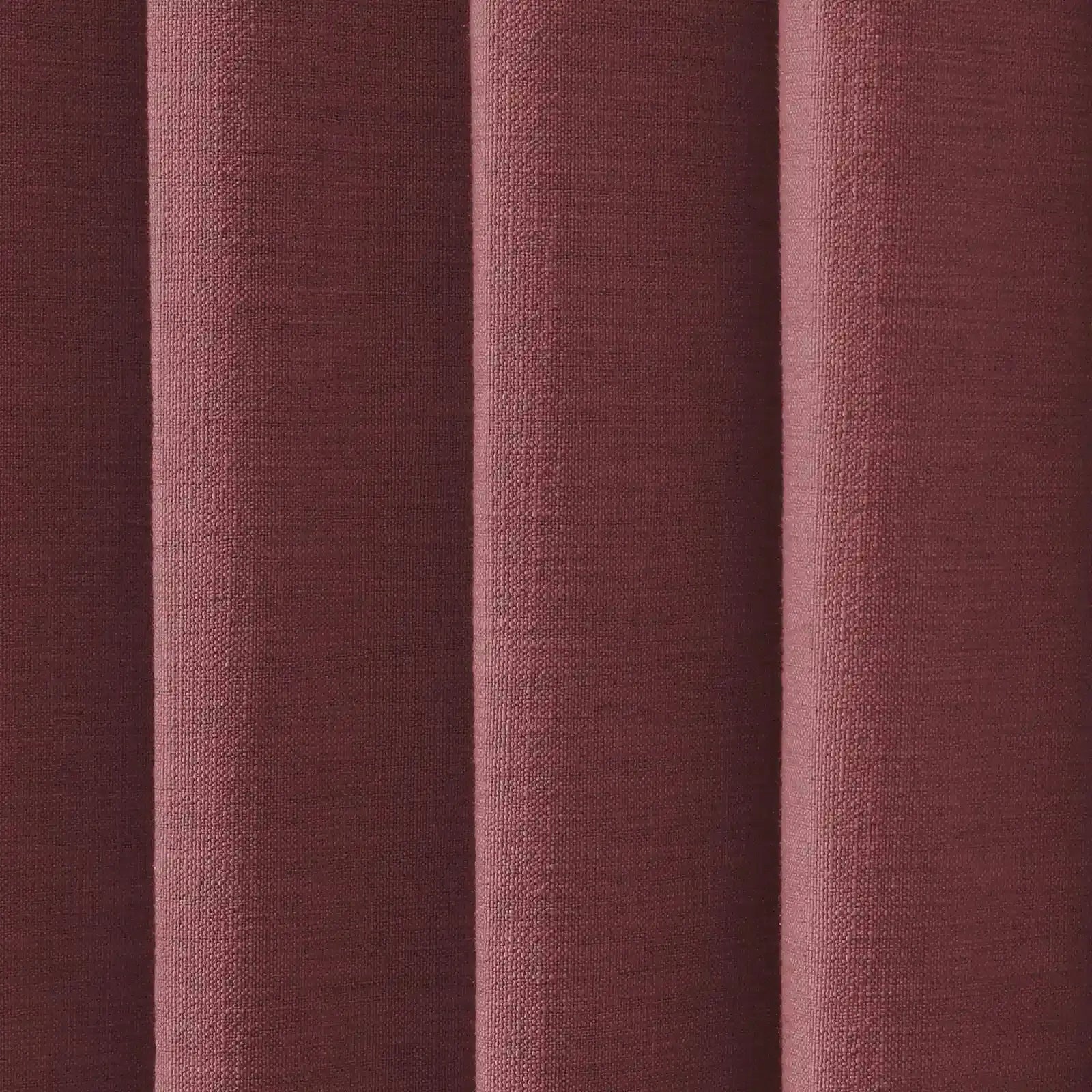 A close-up of textured reddish-brown woven fabric with prominent vertical folds creating shadows and highlights