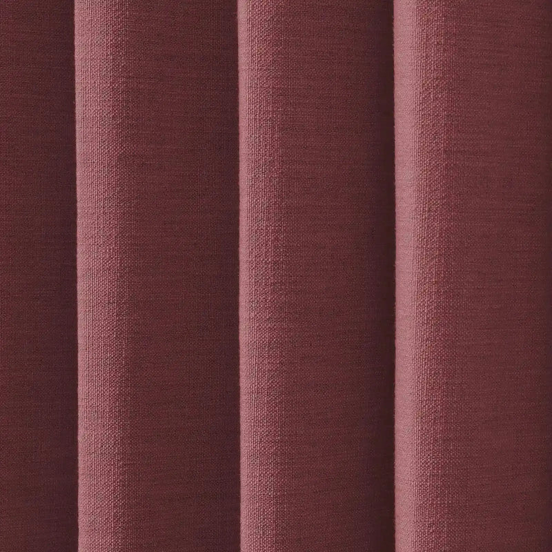 A close-up of textured reddish-brown woven fabric with prominent vertical folds creating shadows and highlights