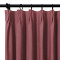 Textured dusty rose curtain panel with tailored pleats on a black rod and rings