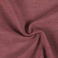 Photograph of a deep dusty rose woven fabric featuring a fine textured surface, soft undulating drapes, and rich tonal shadows