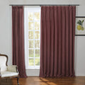Deep maroon pinch pleat curtains frame a white grid window in an interior room, complemented by a classic white upholstered armchair and a framed lemon botanical print