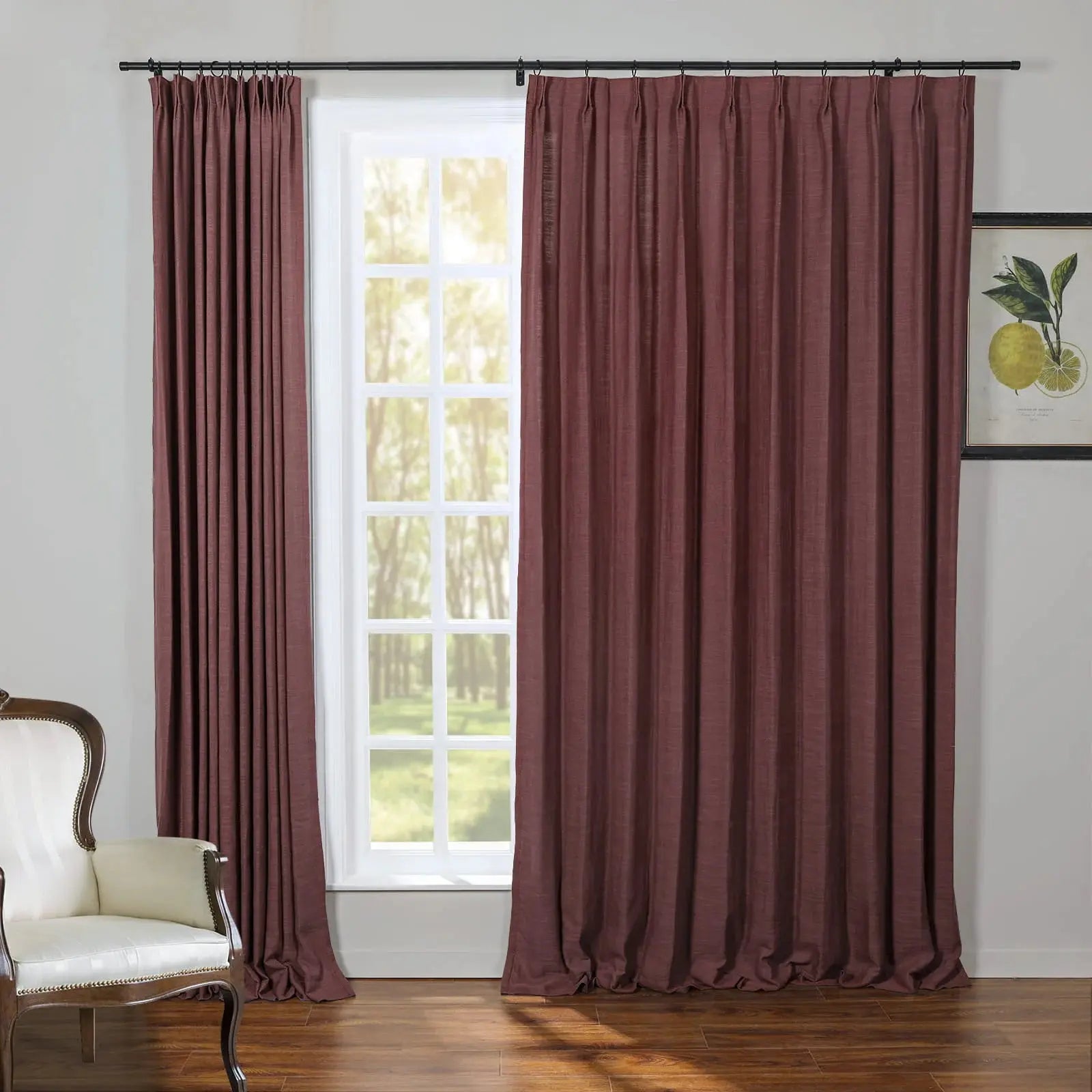 Deep maroon pinch pleat curtains frame a white grid window in an interior room, complemented by a classic white upholstered armchair and a framed lemon botanical print