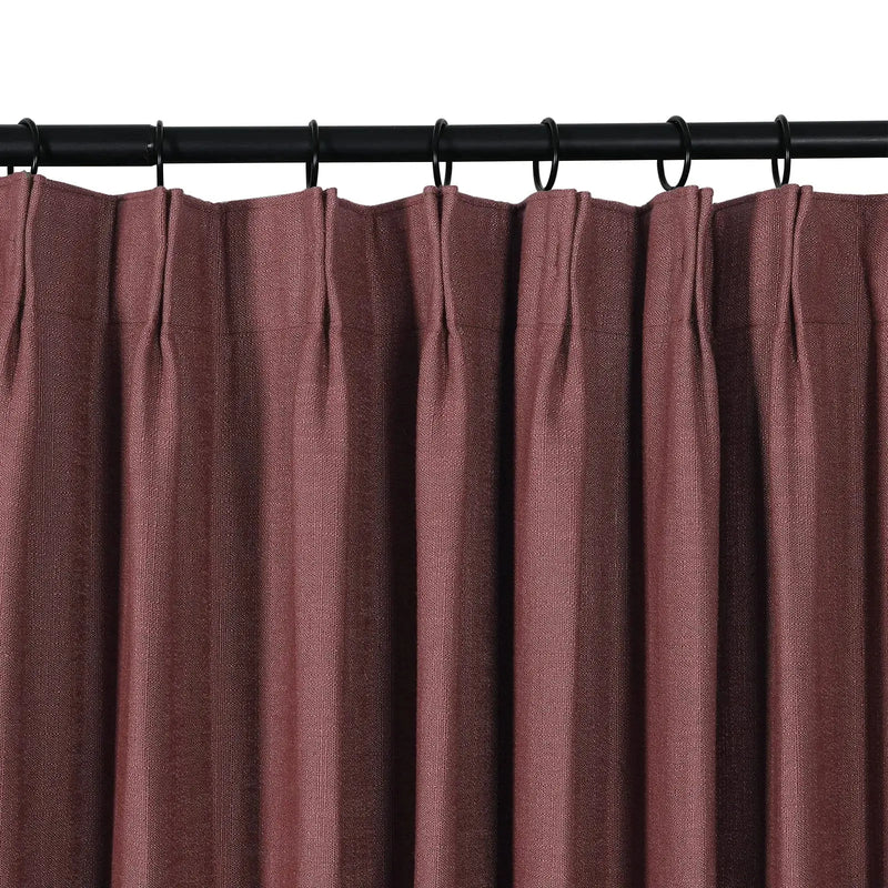 Product photo of a pleated mulberry textured curtain panel hanging from a black rod with rings