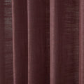 Close-up of a maroon textured curtain featuring distinct vertical folds and a visible coarse weave