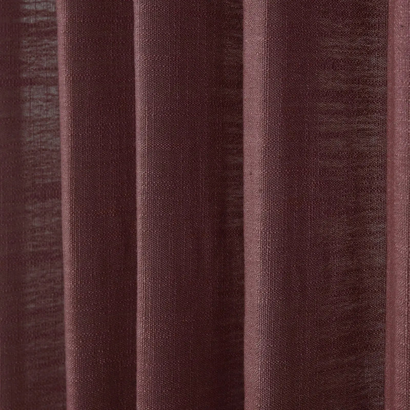 Close-up of a maroon textured curtain featuring distinct vertical folds and a visible coarse weave