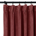 A plush dusty rose velvet curtain with a pinch pleat header hangs from a black rod with rings showing soft vertical folds