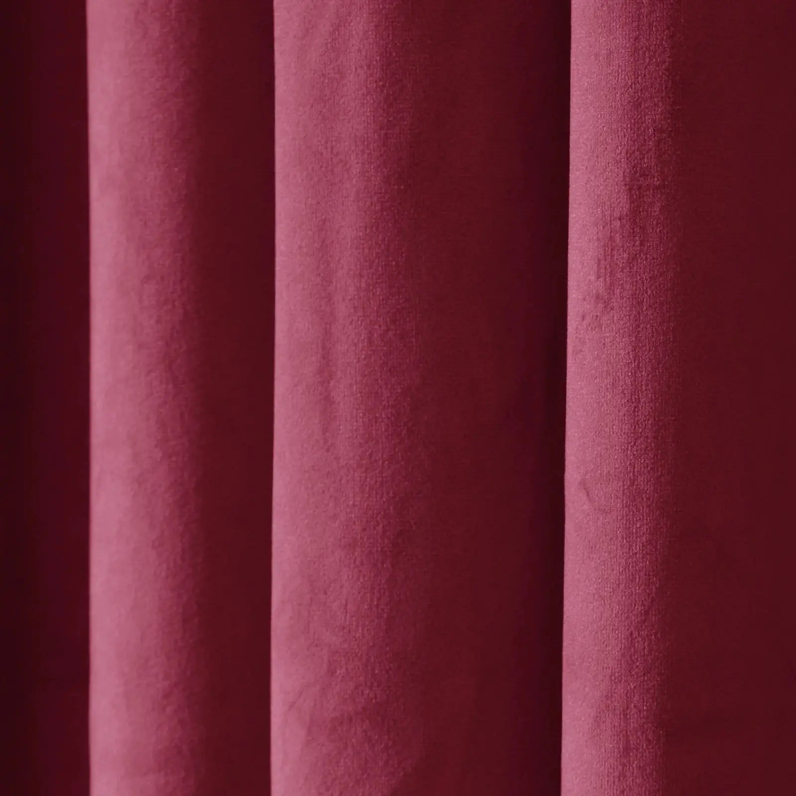 Photograph of rich maroon textured fabric with soft vertical drapes creating subtle shadows