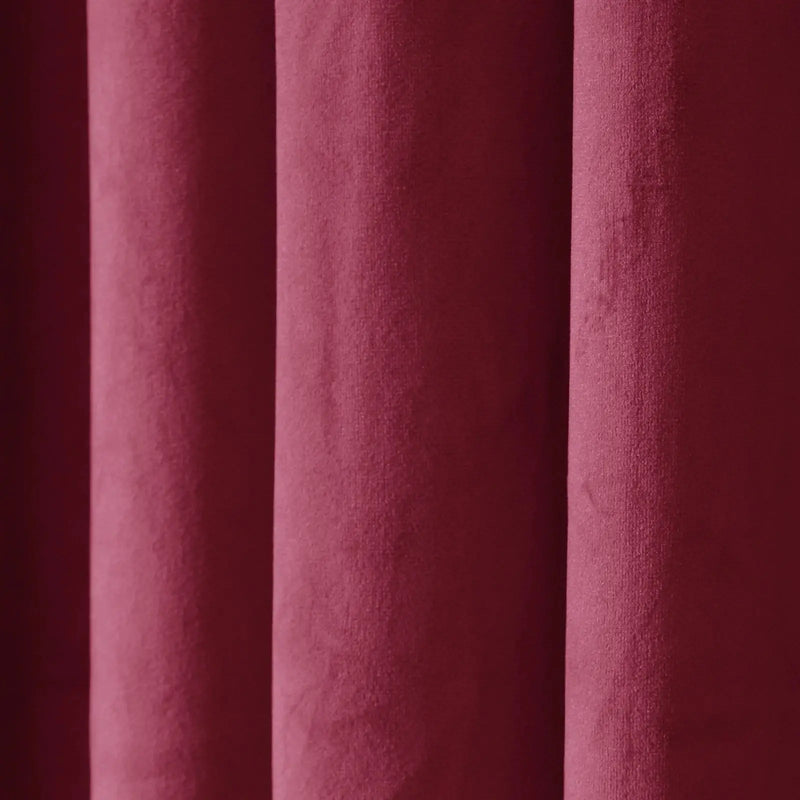 Photograph of rich maroon textured fabric with soft vertical drapes creating subtle shadows