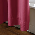 Photograph of a vibrant berry pink fabric curtain featuring soft folds and a neatly stitched hemline resting just above a light wooden floor and white baseboard