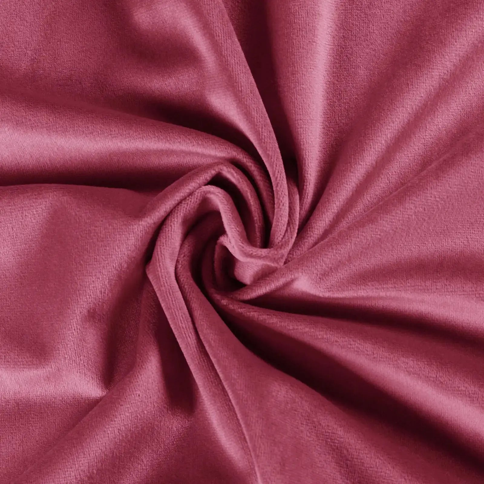 A close-up of plush deep rose pink velvet fabric artfully swirled creating a central rosette pattern and soft light-catching folds