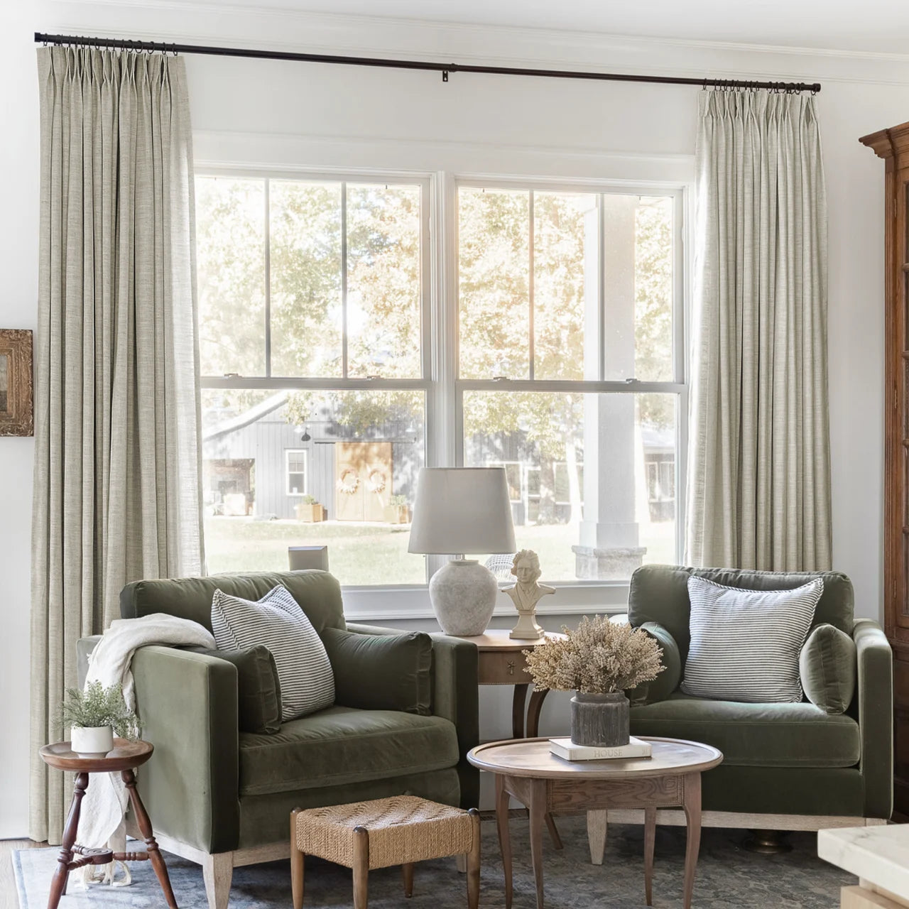 Burlywood Birch Liz Linen Pleated Curtains framing a green sofa beneath a wide sunlit window