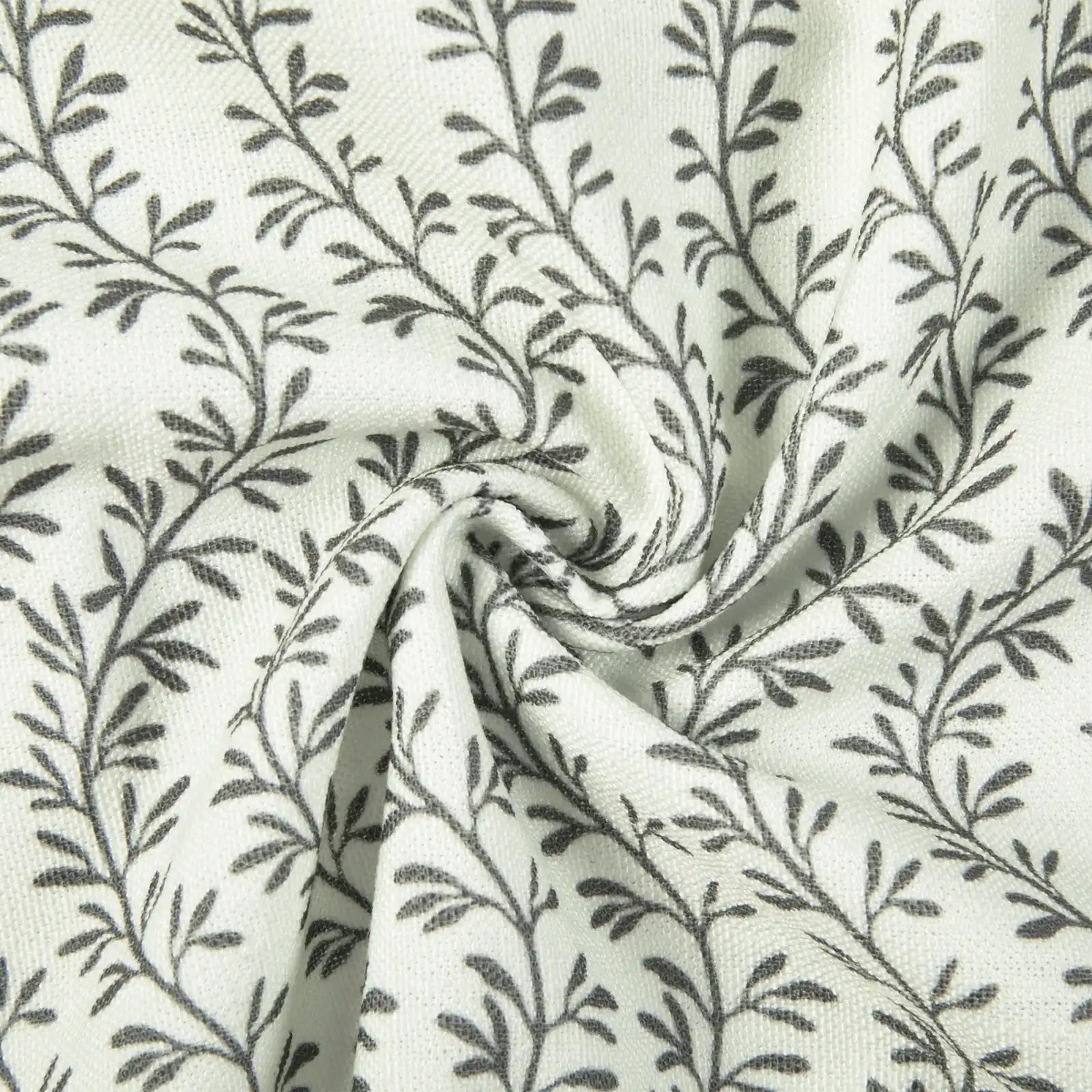 Textile featuring a repeating dark grey botanical leaf pattern on a textured white fabric with a prominent central swirl