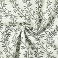 Textile featuring a repeating dark grey botanical leaf pattern on a textured white fabric with a prominent central swirl