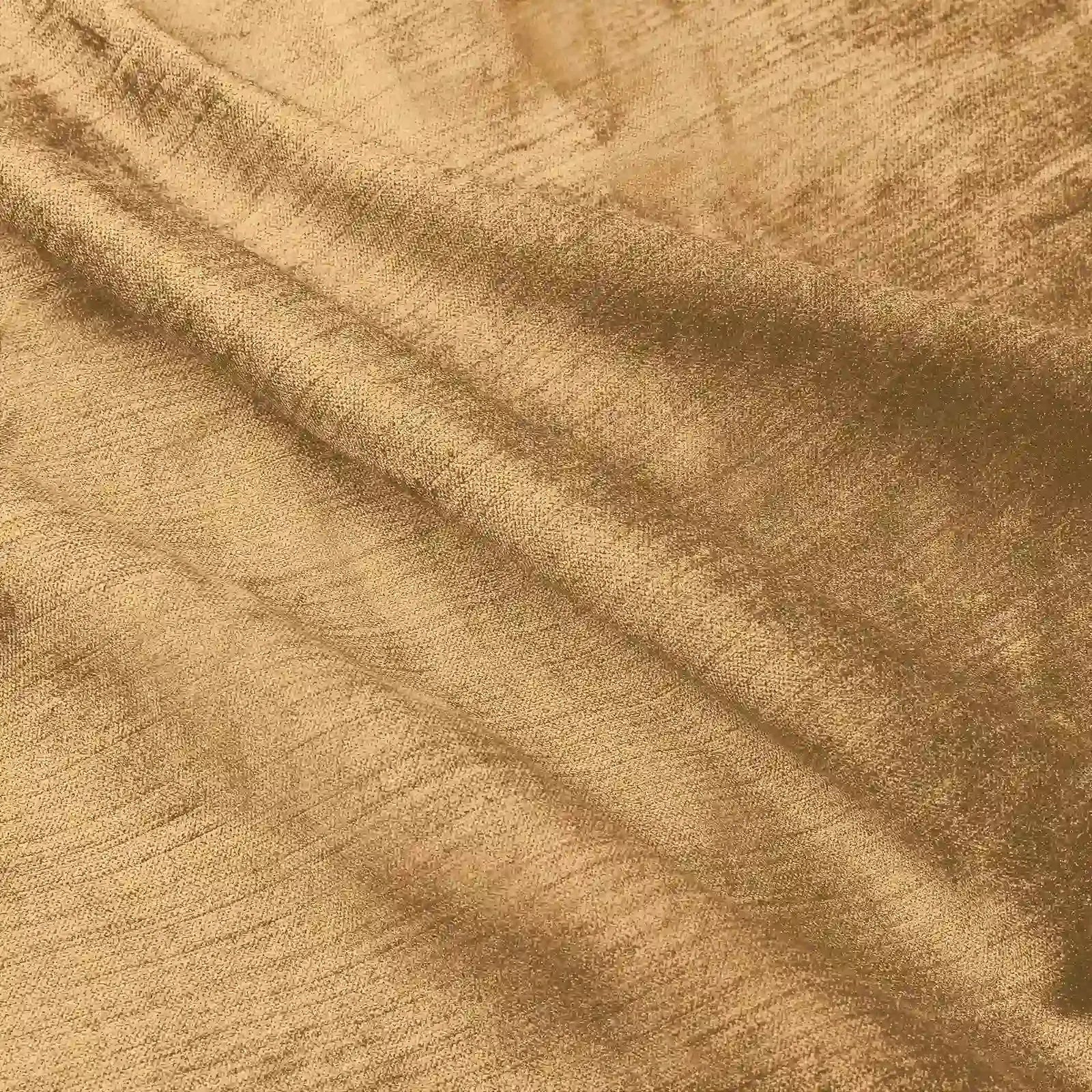 Textured warm golden brown fabric softly draped with crinkled folds highlighting its subtle shimmer and woven thread details