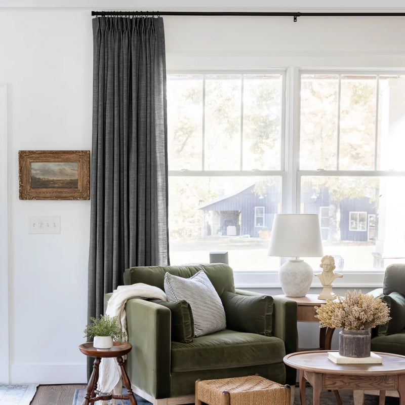 Carbon Grey Liz linen curtains shown closer beside a sunlit window with smooth vertical folds
