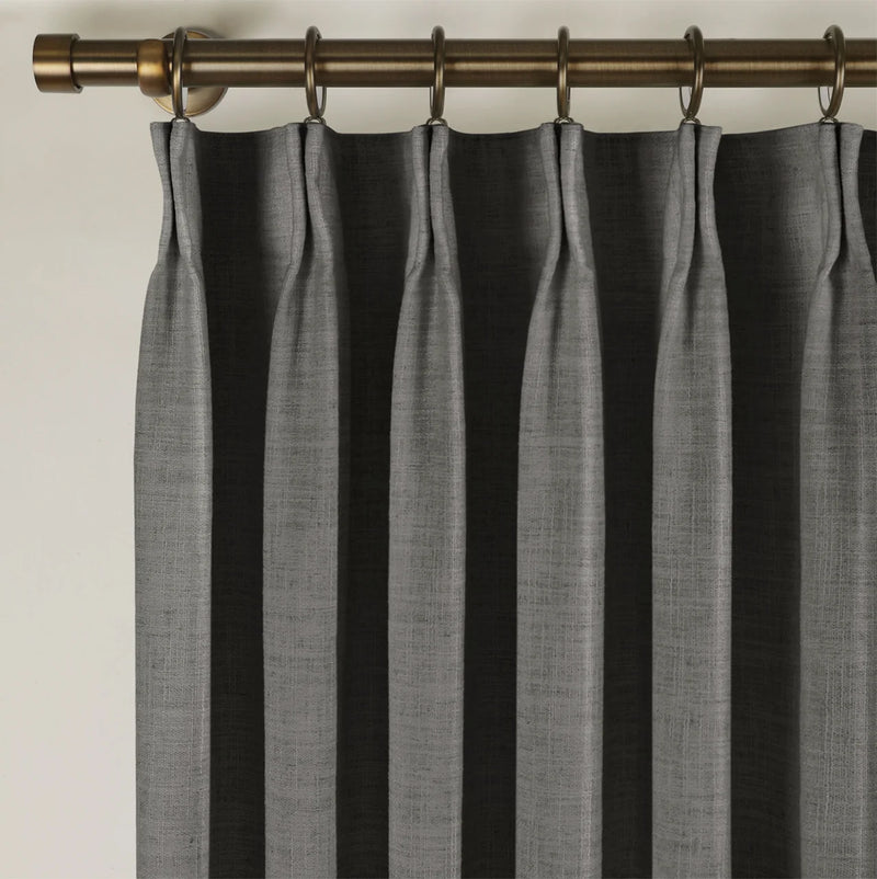 Carbon Grey Liz linen curtains viewed at an angle in a softly styled room with natural daylight