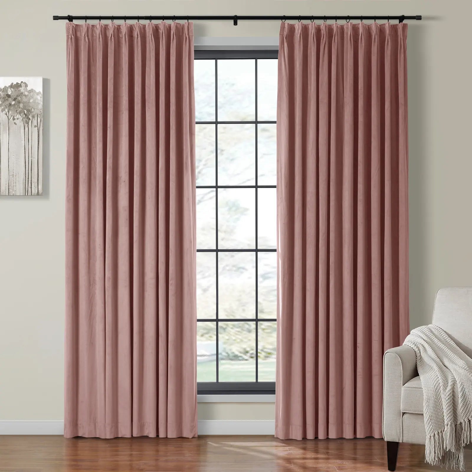 Dusty rose pink velvet pleated curtains framing a black-gridded window in a contemporary room featuring a light grey armchair with a cream throw and abstract tree wall art