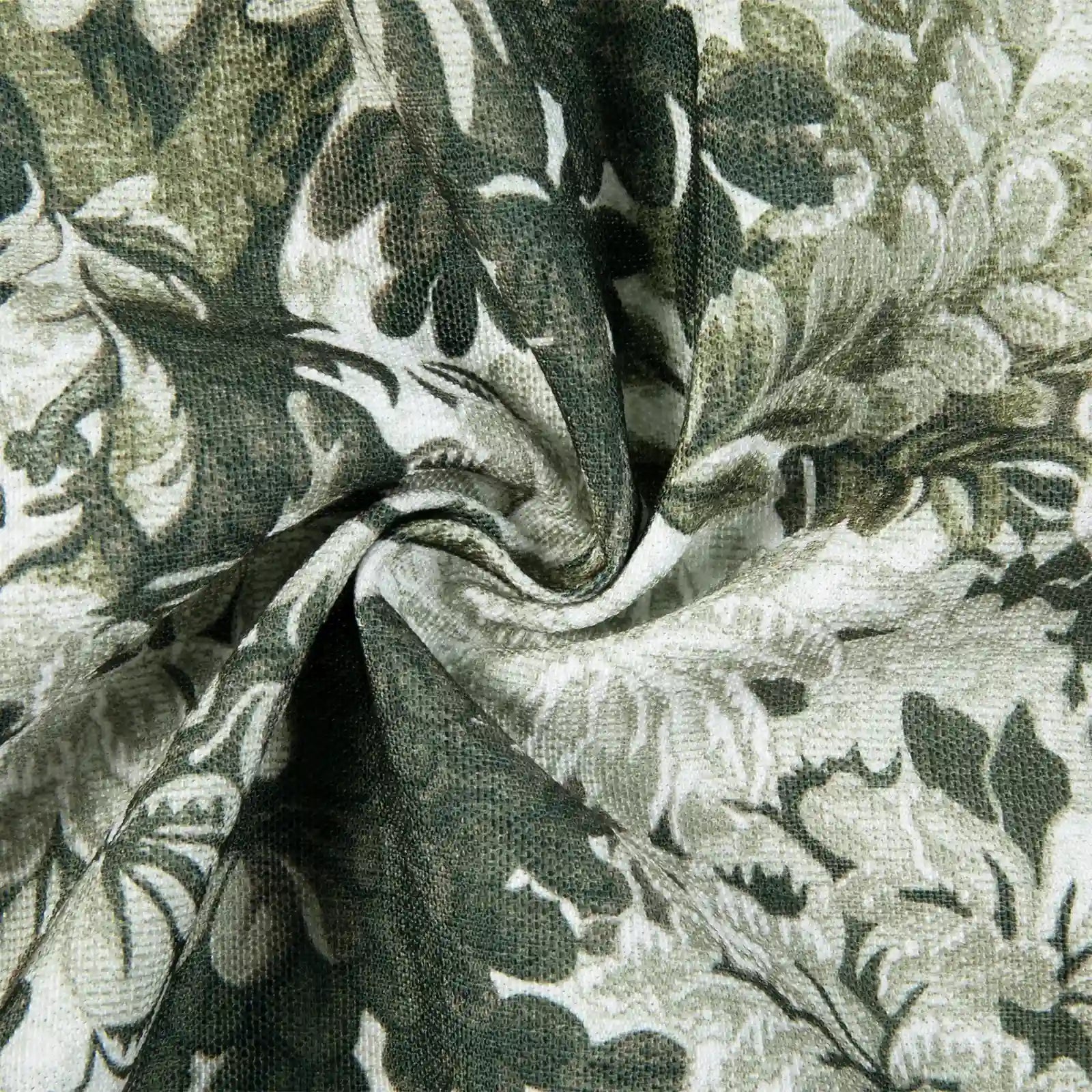 Textile with an olive green and grey floral pattern on white fabric, twisted into a central spiral revealing its woven texture