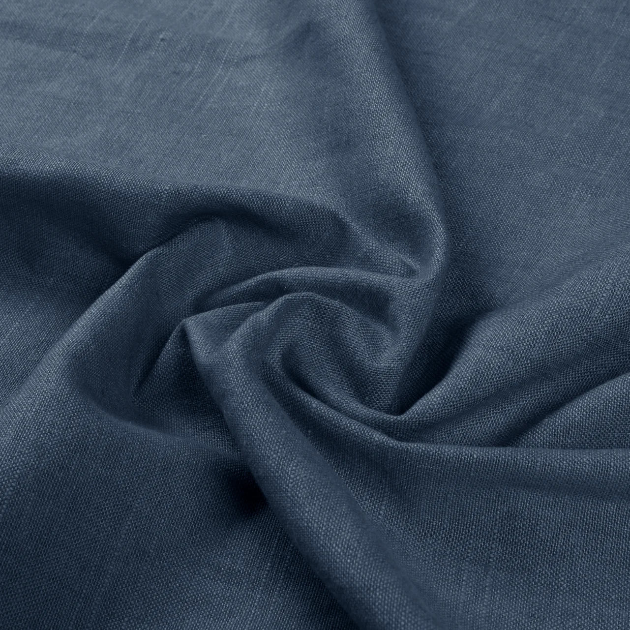 Photograph of dark blue textile fabric with a subtle linen-like texture and dramatic swirling folds casting shadows