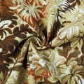Textile fabric with a textured woven tropical floral pattern in earthy brown beige green and terracotta orange hues featuring soft drapes