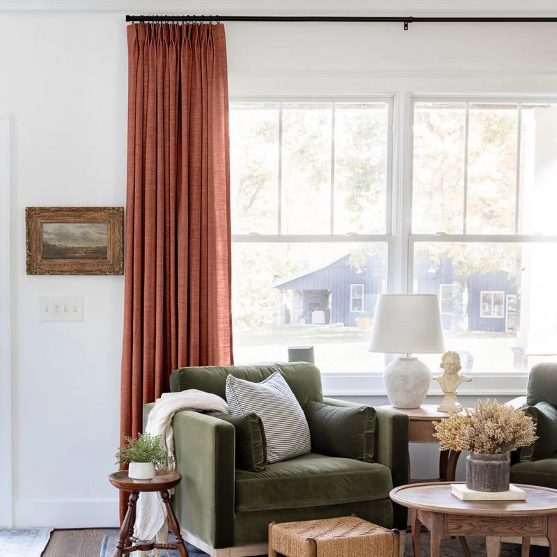 Firebrick Liz linen curtains shown closer beside a sunlit window with smooth vertical folds
