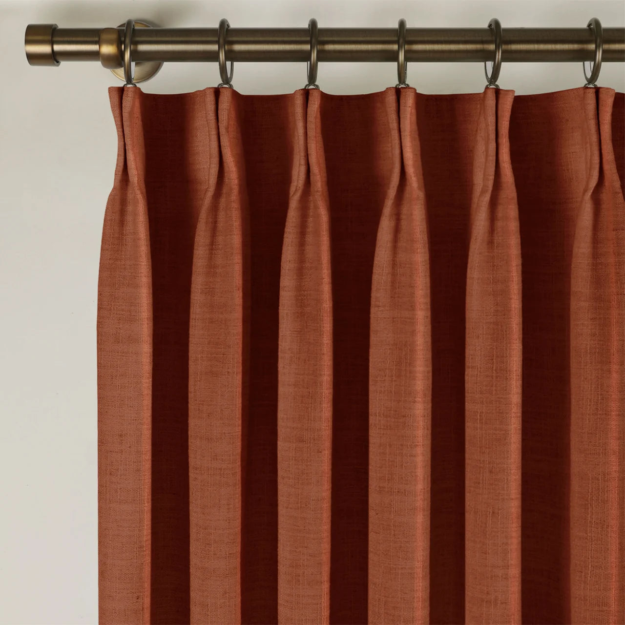 Firebrick Liz linen curtains viewed at an angle in a softly styled room with natural daylight