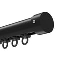 Close-up of a modern matte black curtain track system with a cylindrical end cap secured by a silver hex screw and several dark plastic runners with rings
