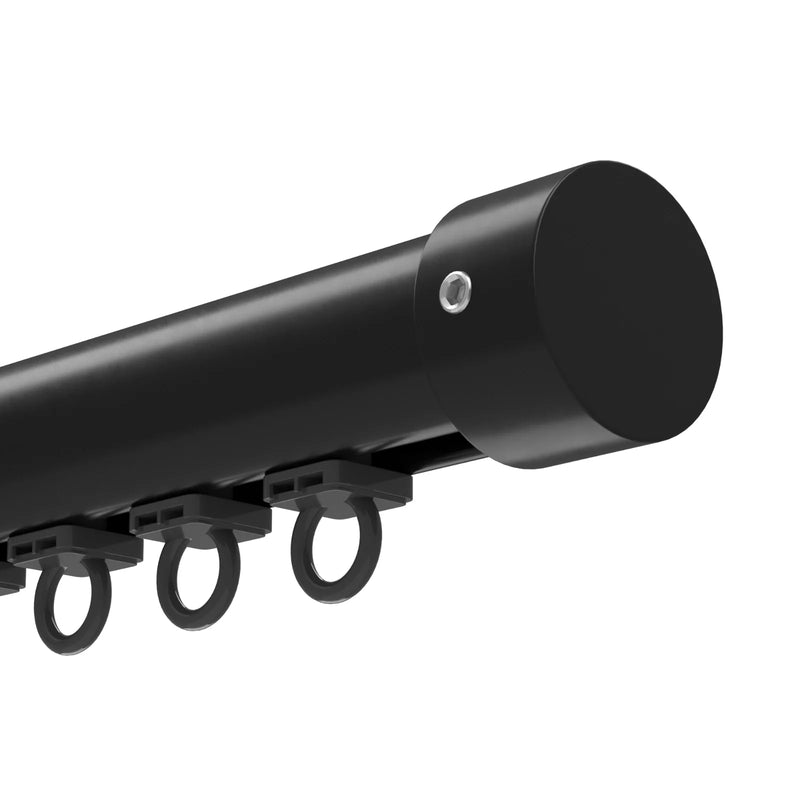 Close-up of a modern matte black curtain track system with a cylindrical end cap secured by a silver hex screw and several dark plastic runners with rings