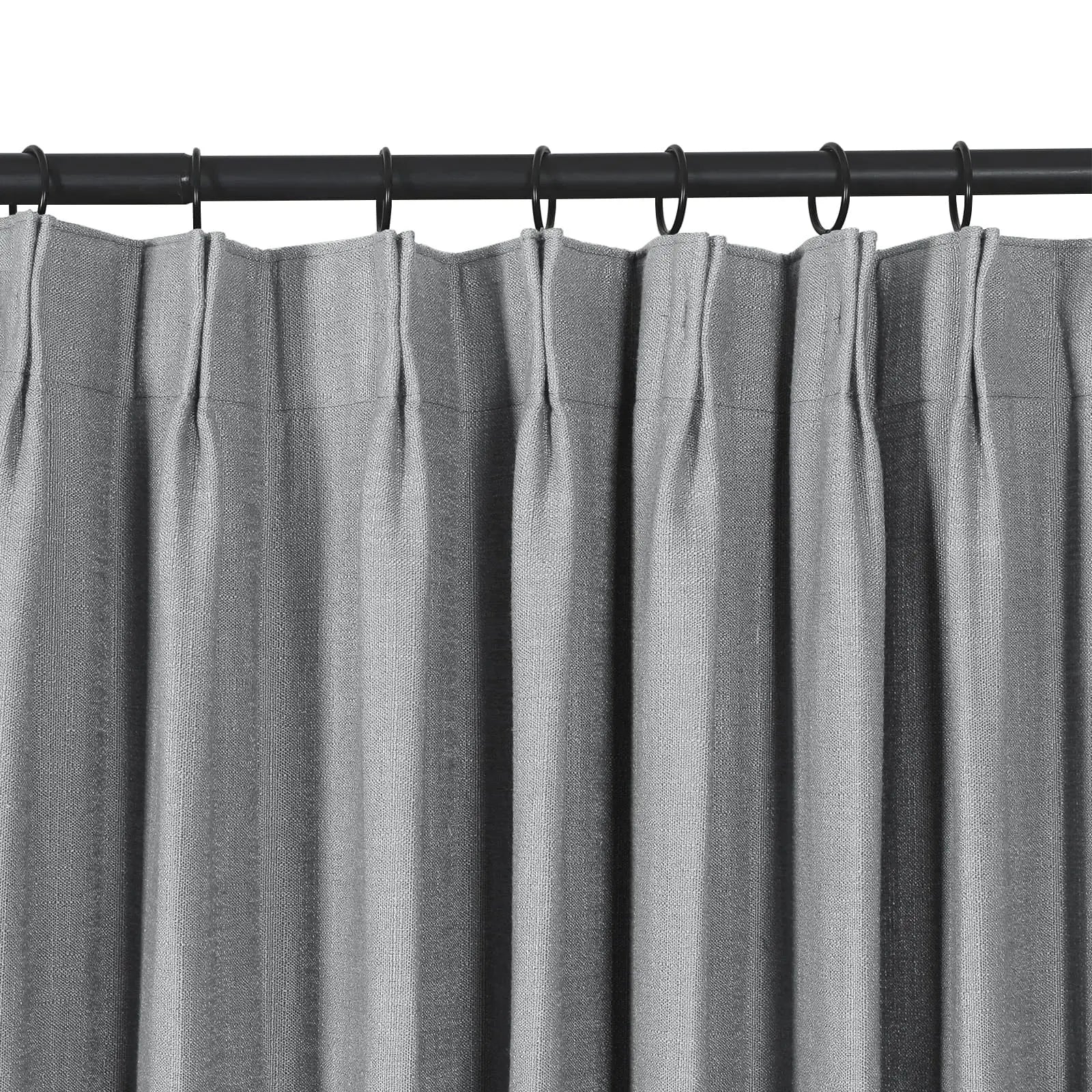 Textured gray pleated curtains on a black metal rod with black rings
