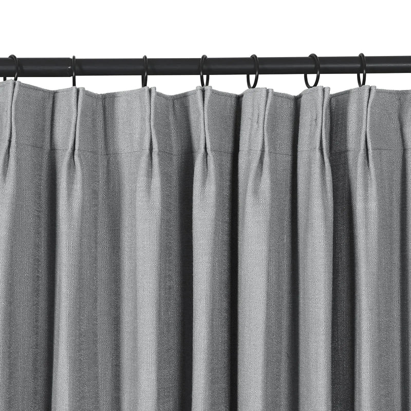 Textured gray pleated curtains on a black metal rod with black rings