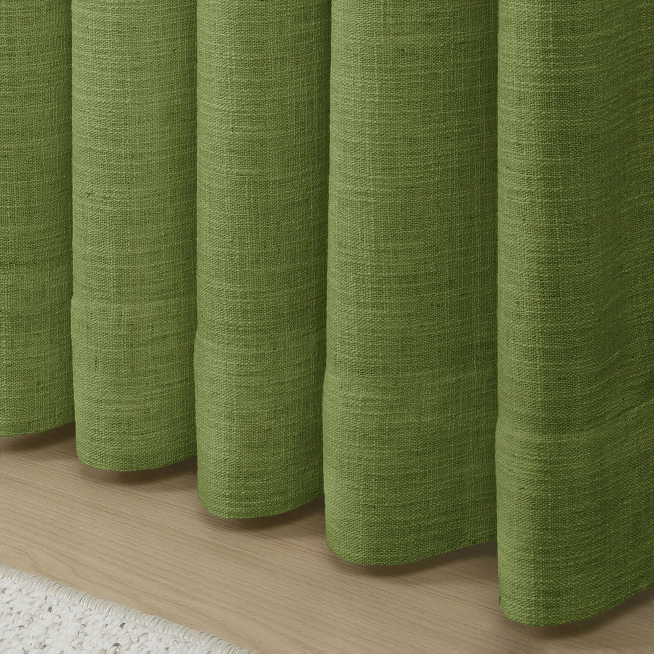 Green Liz linen curtains showing the lower drape and pooling folds near the floor