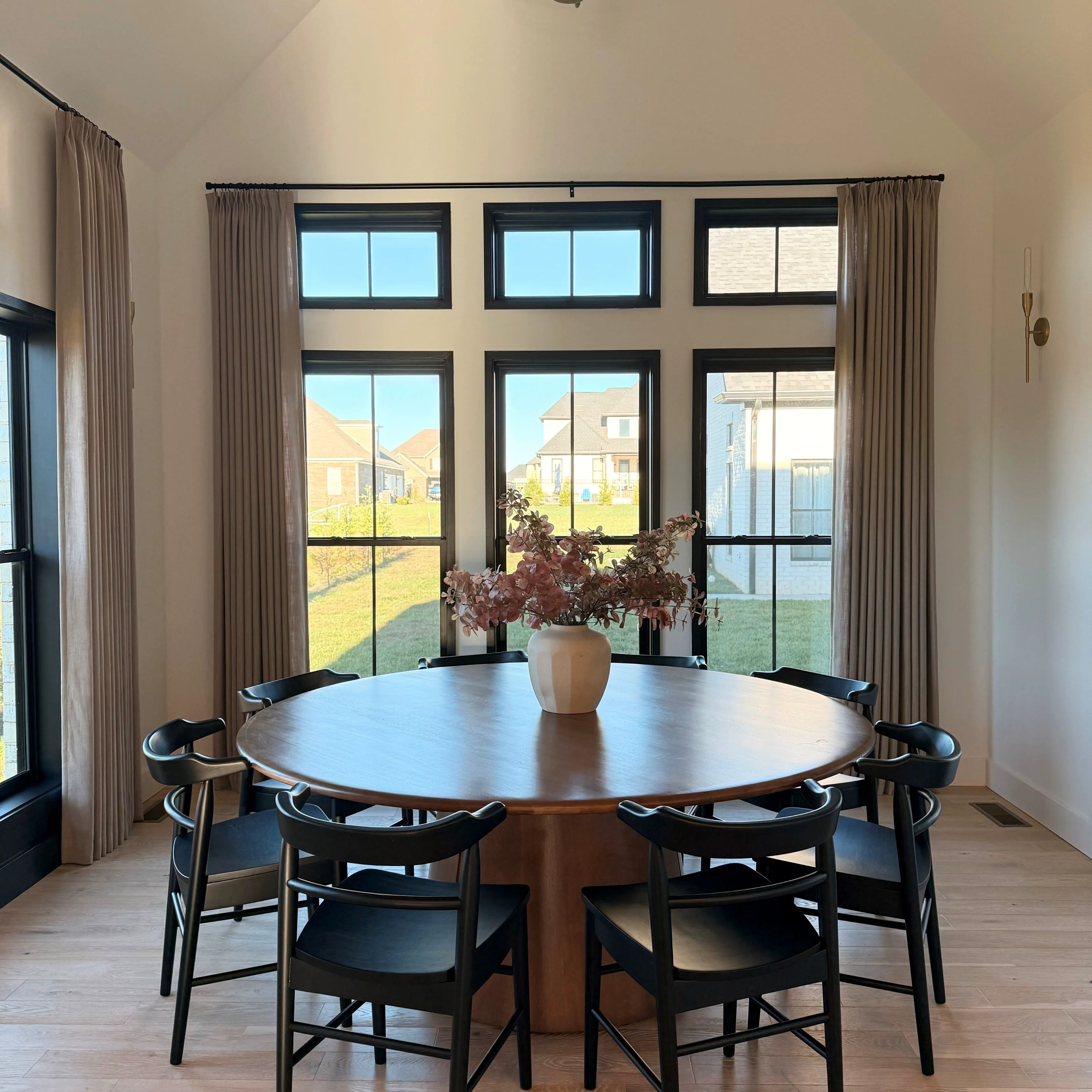 Grey Beige Liz Linen Pleated Curtains around transom windows behind a round dark wood dining table