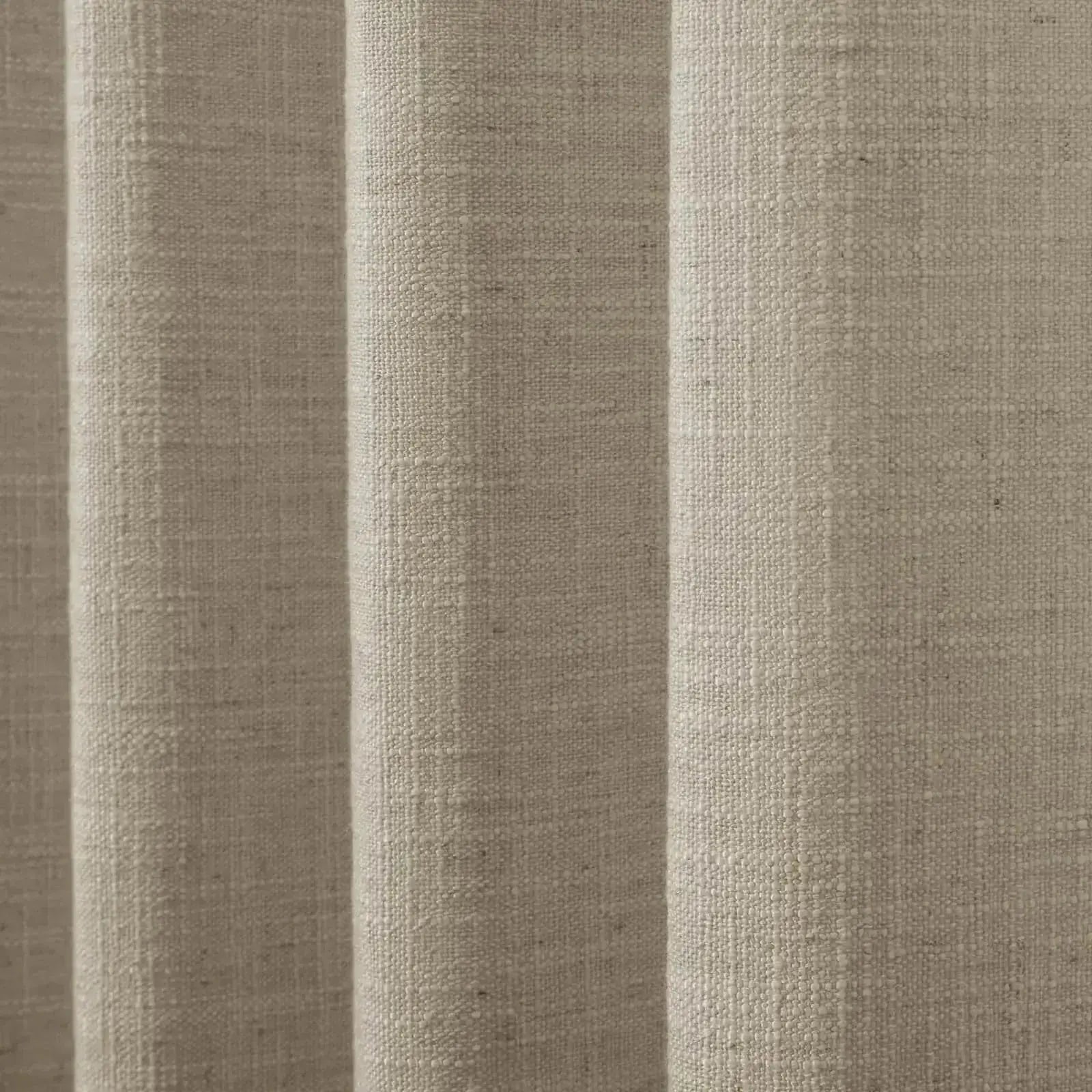 Textile art featuring a close-up of natural oatmeal linen-look fabric with a coarse woven texture and soft vertical pleats