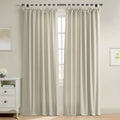 Light beige linen-look curtains with decorative tie-top tabs cover a window in a bright room featuring a white dresser with a blue vase of flowers and framed yellow inspirational artwork