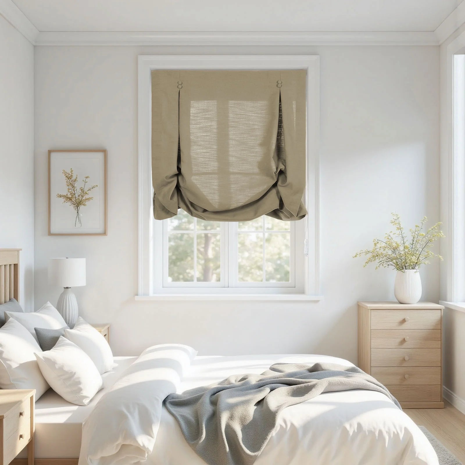 Photograph of a serene, modern bedroom interior featuring a natural linen tie-up Roman shade, light wood furniture including a bed with white bedding and a grey throw, and two arrangements of yellow wildflowers in a framed print and a ribbed white vase