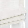 Photograph of textured off-white Roman blinds with three horizontal folds and braided pull cords hanging in a window