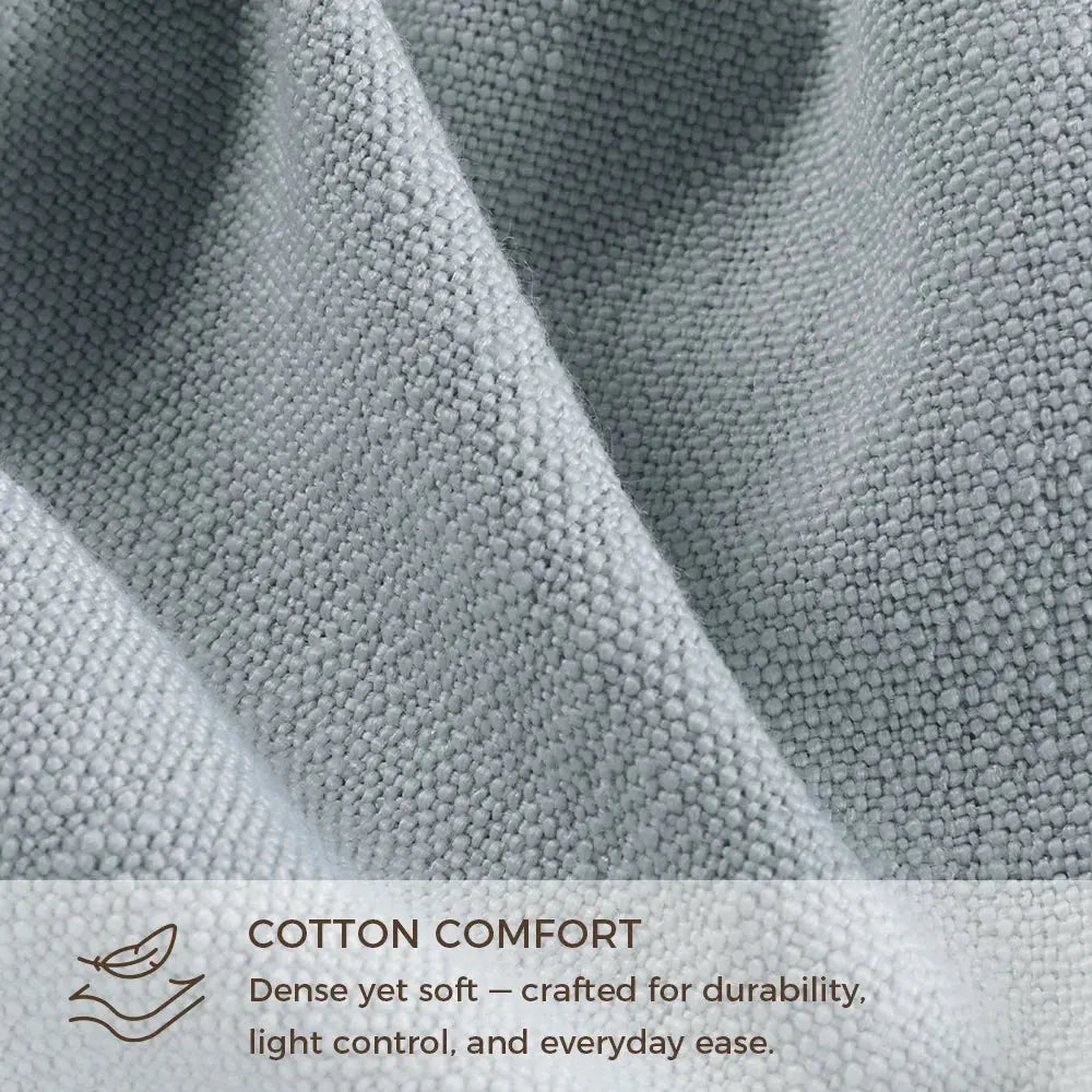 Photograph of a muted light blue densely woven cotton fabric featuring visible texture and soft, flowing folds