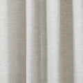 Photograph of light beige textured fabric draped in soft vertical pleats featuring a subtle central seam