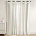 White linen-blend tie-top curtains on a black rod in a bright room, next to a white three-drawer dresser with brass pulls and pink flowers