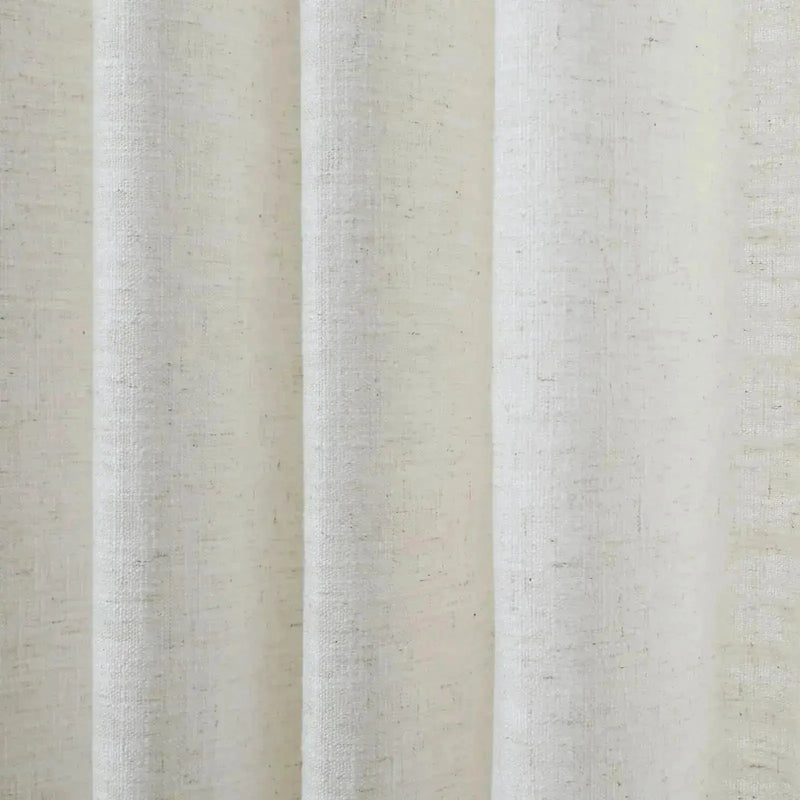 Close-up of a white linen-like textured fabric with prominent vertical folds and subtle dark flecks under soft lighting