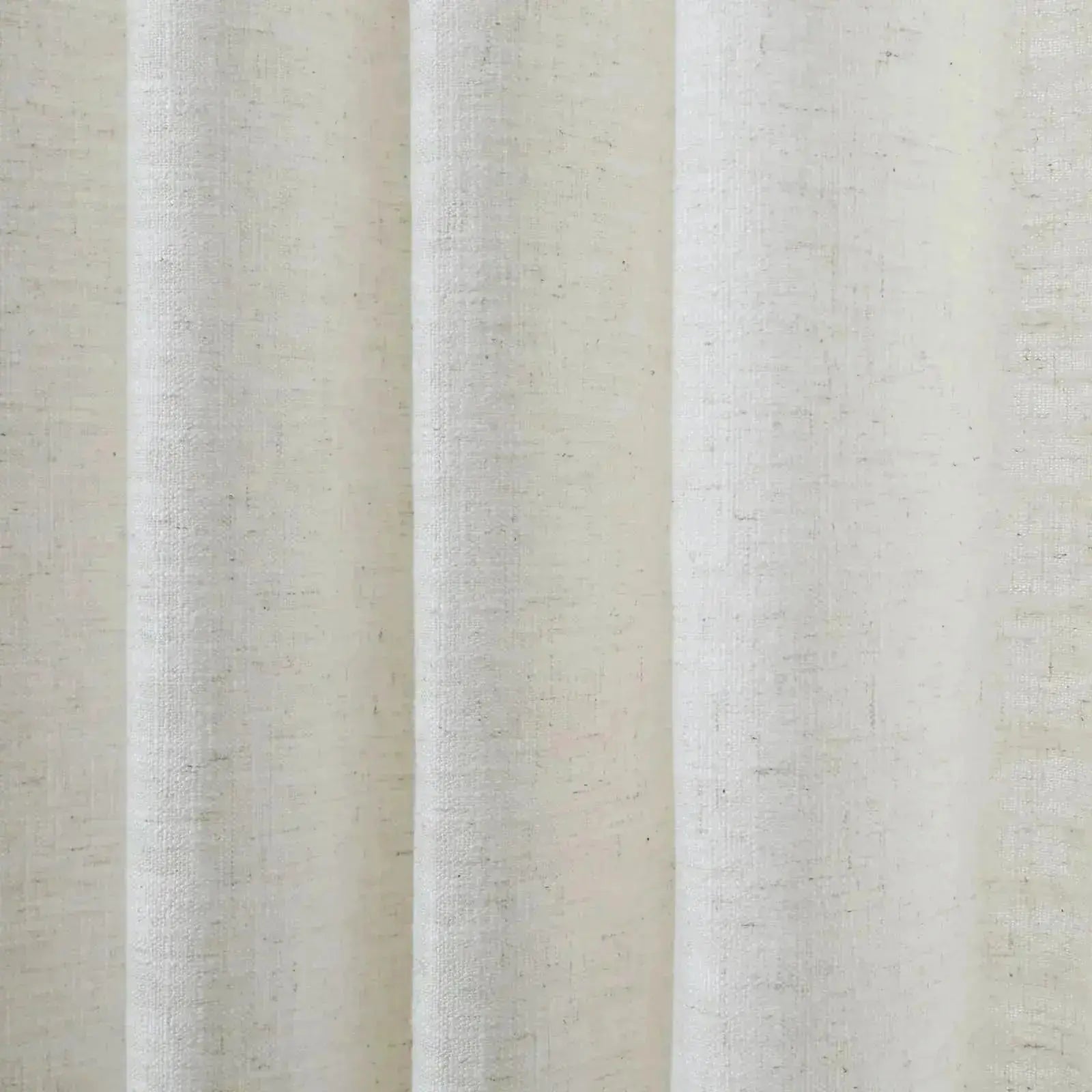 Close-up of a white linen-like textured fabric with prominent vertical folds and subtle dark flecks under soft lighting