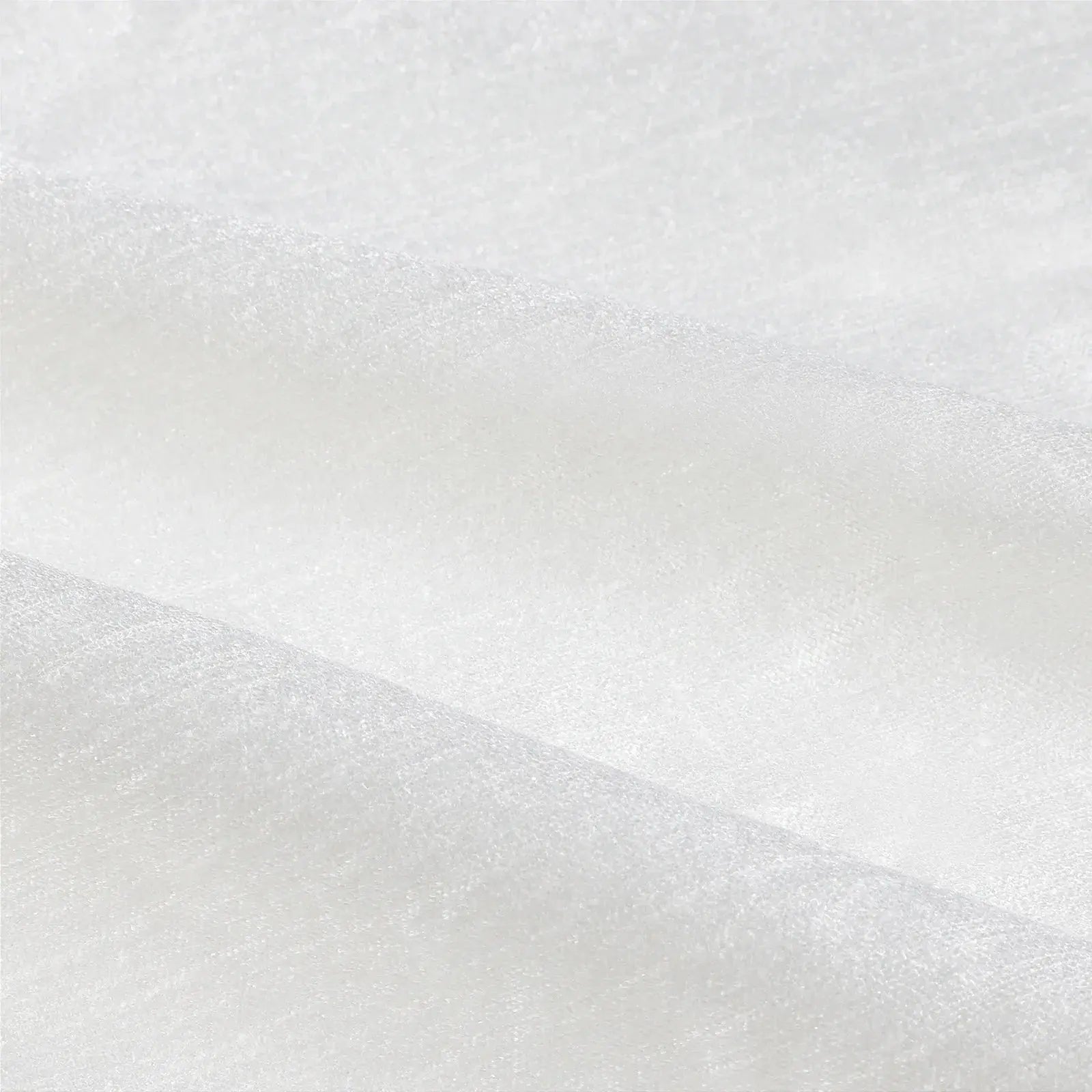 Photograph of white textured fabric with soft creases, a subtle sheen, and a fine weave pattern