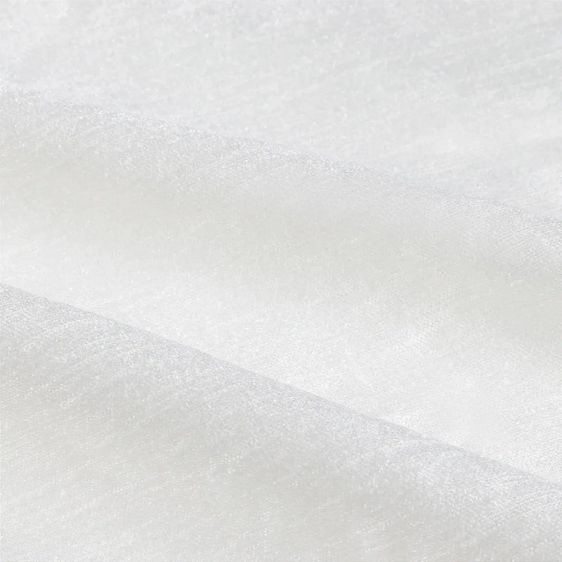Photograph of white textured fabric with soft creases, a subtle sheen, and a fine weave pattern