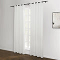 White grommet top curtains hanging on a black rod against a window in a modern room featuring dark wood floors and an abstract monochrome artwork on the wall