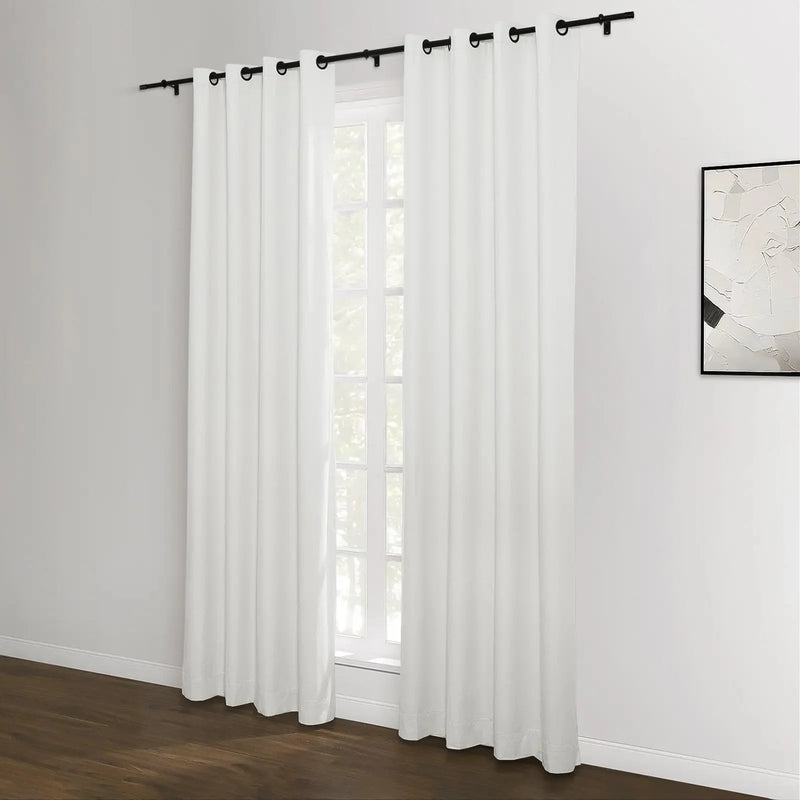 White grommet top curtains hanging on a black rod against a window in a modern room featuring dark wood floors and an abstract monochrome artwork on the wall