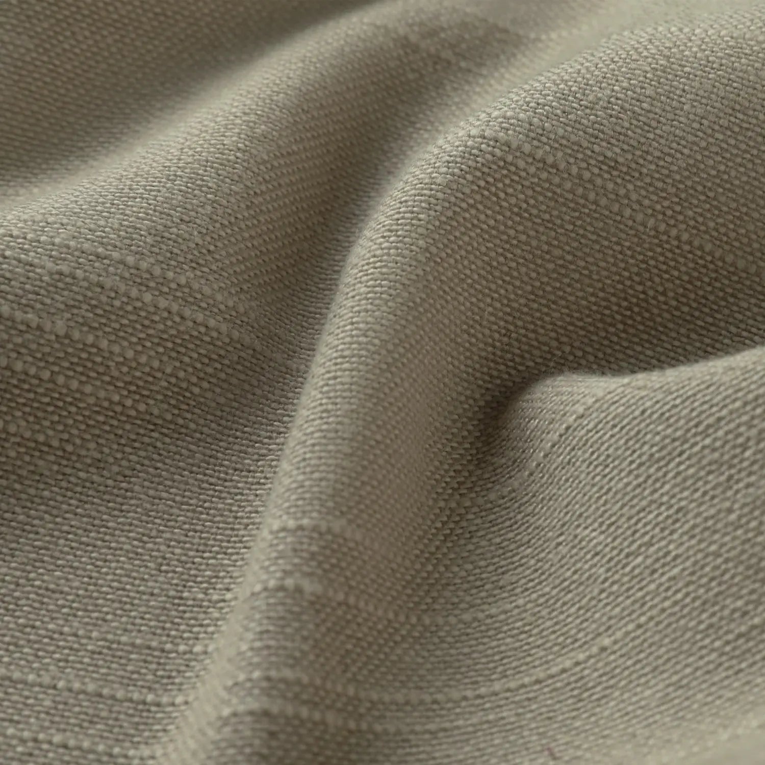 Photograph of a close-up neutral beige textile featuring a visible woven texture and soft natural folds